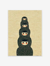 Japanese dolls wall art print showing four stylized figures stacked vertically with black hoods and red cheeks on a textured background.