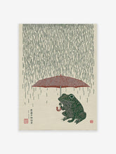 Japanese style illustration of a green frog holding a red umbrella in the rain on a textured beige background.