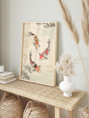 Japanese illustrative print of three orange, red, black, and white koi fish swimming with, in an alternate framed mockup