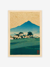 Traditional Japanese landscape woodblock print with a blue mountain, village, green fields, and golden patterned sky.