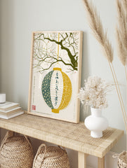 Japanese lantern hanging from cherry blossom tree branch with kanji calligraphy on a white, in an alternate framed mockup