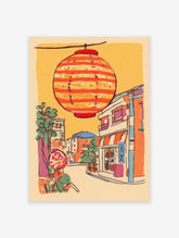 Illustrative print of a Japanese street scene with a large orange striped lantern hanging above colorful buildings and trees.