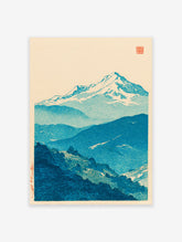 Traditional Japanese woodblock print of blue snow-capped mountains and forested hills against a cream sky.