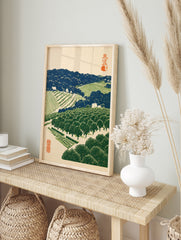 Japanese landscape woodblock style print of a terraced orchard with orange trees, blue hills, in an alternate framed mockup