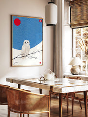White owl with golden details perched on a branch, red sun and wavy blue sky in Japanese, in a styled room mockup