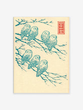 Japanese owl wall art showing seven teal owls on tree branches in a woodblock print style on a cream background.