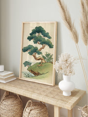 Stylised Japanese pine tree illustration on a grassy cliff with green foliage and brown, in an alternate framed mockup