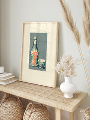 Japanese sake bottle and cup illustration with teal patterns and orange kanji on a grey, in an alternate framed mockup