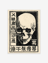 Black and white Japanese skull art print with kanji text on a light background, vintage illustrative style.
