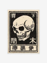 Japanese skull art print in vintage woodblock style with Kanji characters on an off-white background.