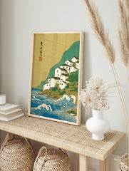 Japanese ukiyo-e style print of a white coastal village on a green cliff overlooking blue ocean waves with a gold sky. - Image 3