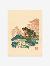 Japanese wall art print featuring a green and orange frog on lily pads with a traditional temple and trees in the background.