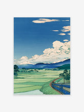 Japanese landscape wall art print with a blue train, green rice fields, mountains, and white clouds in a blue sky.