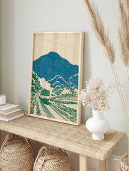 Japanese wall art print of a green train traveling through a blue mountain and green tree landscape with a cream background. - Image 3