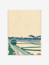 Japanese Wall Art print of a green train on tracks, blue mountains, and rice fields, in a vintage woodblock style.