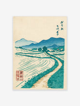 Vintage Japanese woodblock landscape print featuring blue mountains, green fields, and a winding path, with Japanese calligraphy.