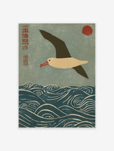 Japanese woodblock print of an albatross flying over blue waves with a red sun and kanji script