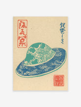 Traditional Japanese Woodblock Print depicting a blue and teal patterned hat with cultural characters on a beige background.