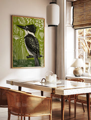 Linocut-style art print of a black and white kingfisher bird on a branch, vibrant green background, in a styled room mockup