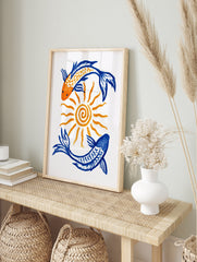 Illustrative art print featuring two koi fish in orange and blue circling a central sun on a, in an alternate framed mockup