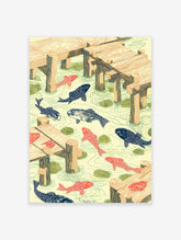 Woodcut style Koi Pond Wall Art with orange and blue fish, green lily pads, and wooden docks in light yellow water.