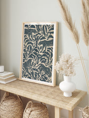 Stylised leopard pattern wall art featuring navy blue jungle foliage and big cats on a cream, in an alternate framed mockup