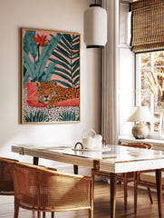 Leopard resting on a red cushion with tropical foliage and a pink background art print, in a styled room mockup