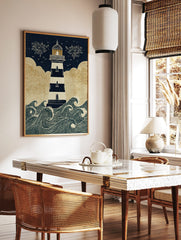Illustrative lighthouse wall art with navy and white stripes, golden clouds, and crashing waves, in a styled room mockup