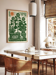 Lino-cut garden art print with sunflowers, potted herbs, pumpkin, and cabbage on a brick wall under, in a styled room mockup