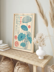 Japanese woodblock style art print of blue lotus leaves and stems with red seals and vertical, in an alternate framed mockup