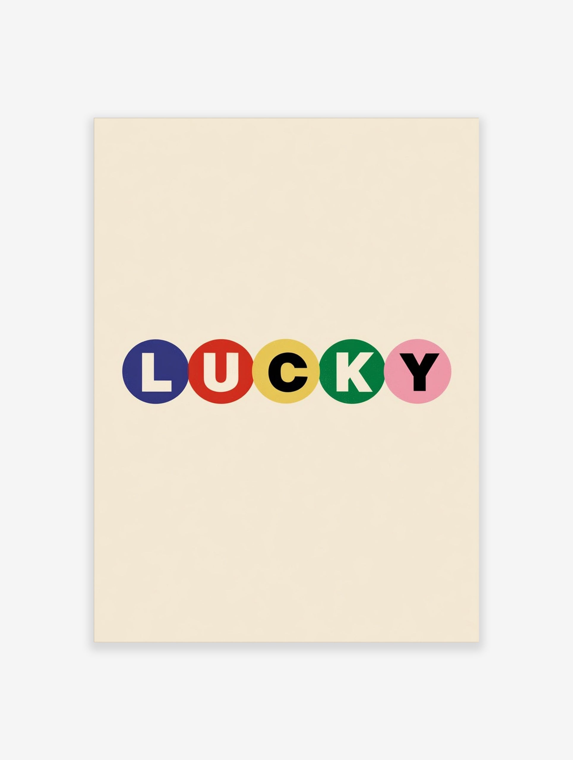 Typography wall art with the word LUCKY in blue, red, yellow, green, and pink circles on a cream background