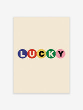 Typography wall art with the word LUCKY in blue, red, yellow, green, and pink circles on a cream background