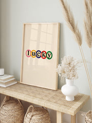 Lucky typography wall art print with colourful letters in circles on a neutral background, in an alternate framed mockup