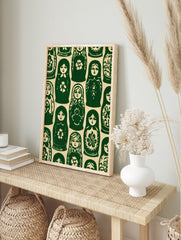 Repeating pattern of green and cream Matryoshka nesting dolls in a folk art illustrative style, in an alternate framed mockup