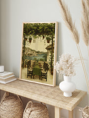 Mediterranean coastal wall art showing an al fresco dining terrace with green pergola overlooking a seaside town and blue sea. - Image 3