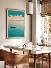 Minimalist art print of a lone boat on a teal sea under a pale, cloudy sky, evoking calm, in a styled room mockup