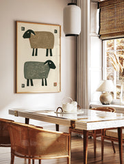 Minimalist sheep illustration with two stylized sheep in brown and grey against an off-white, in a styled room mockup