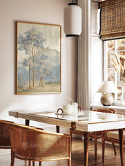 Painterly landscape art print with blue and beige trees, misty forest, and distant mountains under, in a styled room mockup