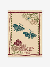 Illustrative Moth & Floral Wall Art print featuring two teal moths, red and green flowers, and a patterned border on a beige background.
