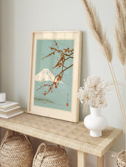 Japanese art print featuring a snow-capped Mount Fuji behind a branch of vibrant red plum, in an alternate framed mockup