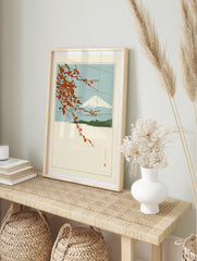 Japanese-style Mount Fuji landscape print with red cherry blossom branches and blue sky, in an alternate framed mockup