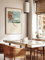 Japanese-style Mount Fuji landscape print with red cherry blossom branches and blue sky, in a styled room mockup