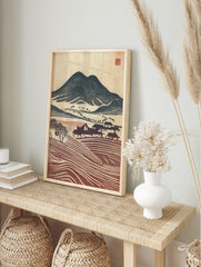 Woodblock print of navy mountains, red terraced fields, and houses in a rustic village, in an alternate framed mockup