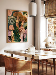 Botanical art print of forest mushrooms and a curled fern frond in shades of orange, green, and, in a styled room mockup