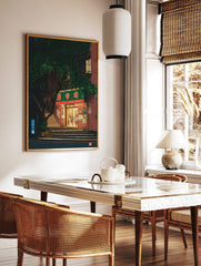 Illustrative print of a shop entrance at night, with a green sign, steps, and a large tree, in a styled room mockup