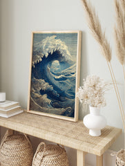Illustrative blue ocean wave art print in woodcut style, showing a large breaking wave with, in an alternate framed mockup