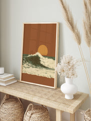 Illustrative ocean wave crashing against a dark teal sea under an orange sunset sky with a, in an alternate framed mockup