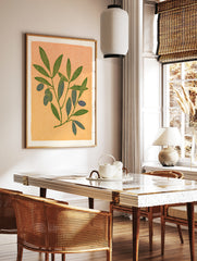 Botanical illustration of an olive branch with green leaves and blue olives on a textured peach, in a styled room mockup