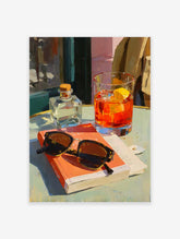 Orange cocktail art poster featuring a vibrant painting of a drink, sunglasses, and a book on a cafe table.