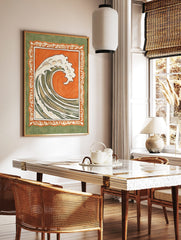 Stylised ocean wave illustration with white foam, orange background, and ornate green border in, in a styled room mockup